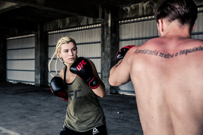 UFC Muay Thai Style Training Gloves
DON’T JUST FUNCTION, PERFORM

Enhance your endurance, strength and sparring skills with this high-energy impact dispersing Thai-style training glove. The internal hand compartment offers a secure, snug fit without sacrificing comfort. Layers of high-density moulded foam keep hands protected during heavy sparring and bag workout sessions. Rigid wrap-around hook &amp; loop closure supports wrist.