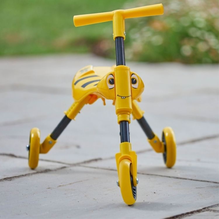 Yellow Scuttlebug tricycle shown in its 3-click folded position for storage