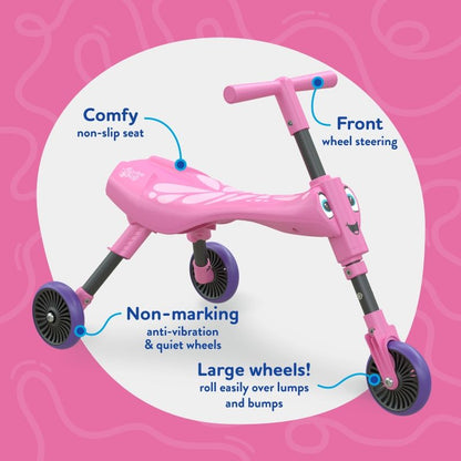 Toddler riding the Scuttlebug butterfly tricycle on an indoor floor