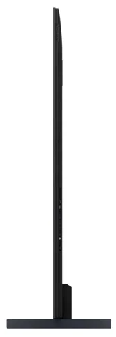 The massive 98 inch TCL television mounted in a premium modern living room displaying a vivid console video game
