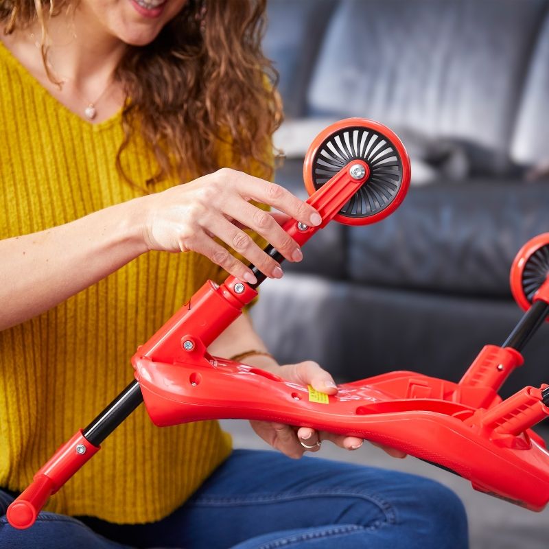 Toddler using a Scuttlebug ride-on bike on indoor flooring