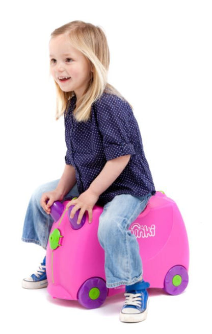 Side profile view of Trixie pink Trunki ride-on suitcase with 4 wheels